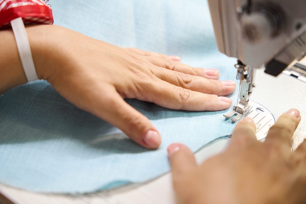 Woman sews a dress on a sewing machine